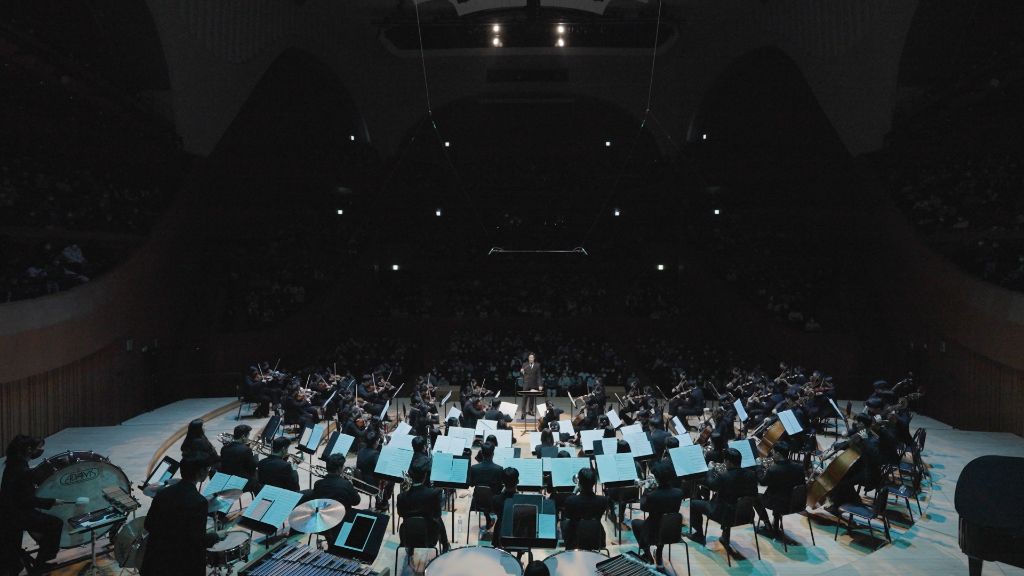 Orchestra performing under stage lights